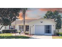 Charming single-story home with well-maintained landscaping and a screened garage in a tranquil neighborhood at 308 Santa Clara Cir, Lady Lake, FL 32159