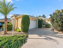 Charming home featuring a well-manicured lawn, two-car garage, and lush landscaping at 3213 Archer Ave, The Villages, FL 32162