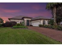 Elegant one-story home with brick driveway and landscaping at 38626 Lakeview Walk, Lady Lake, FL 32159