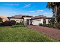 One-story home with stone accents and a brick driveway at 38626 Lakeview Walk, Lady Lake, FL 32159