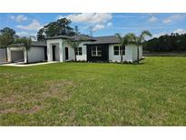 New construction home boasts a modern design, a well manicured lawn, and fresh landscaping at 39817 Forest Dr, Eustis, FL 32736