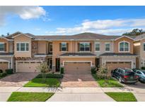 Two-story townhome with two-car garage and landscaped front yard at 765 Walkers Grove Ln, Winter Garden, FL 34787