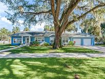 Charming light blue house with mature oak trees and a spacious driveway at 1200 S 7Th St, Leesburg, FL 34748