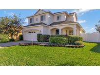 Two-story house with a white exterior, landscaping, and a two-car garage at 15836 Starlite St, Clermont, FL 34714