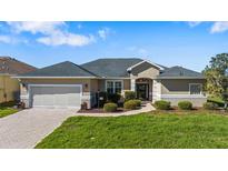 Charming single-story home featuring a well-manicured lawn and a welcoming entrance at 17350 Se 116Th Court Rd, Summerfield, FL 34491