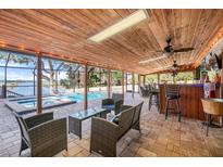 Covered patio with pool, spa, and lake views; an entertainer's dream at 18033 Rose St, Groveland, FL 34736