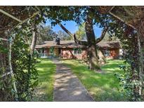 Rustic log home with a charming walkway, surrounded by lush landscaping at 19315 Dorr Rd, Altoona, FL 32702