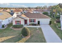 Single-story house with brown roof, red door, and landscaped yard at 2486 Five Forks Trl, The Villages, FL 32162