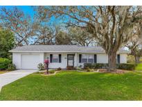White house with green lawn and driveway at 26117 Newcombe, Leesburg, FL 34748
