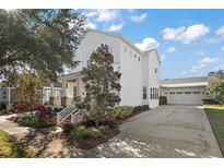 Stunning exterior of a two story home, featuring a well-manicured lawn, white siding and a long driveway at 2746 Se 19Th Ct, Ocala, FL 34471