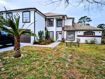 Two-story house with white exterior, brown accents, and a landscaped yard at 3180 Sixma Rd, Lake Helen, FL 32744