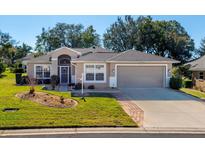 Attractive single-story home with a landscaped lawn and two-car garage at 5305 Indian Ocean Loop, Tavares, FL 32778
