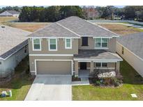 Two-story house with gray siding, gray roof, and a two-car garage at 8511 Triumph Cir, Wildwood, FL 34785