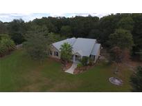 Single-story home with a large yard, located in a wooded area at 9622 Dr Baker Rd, Groveland, FL 34736