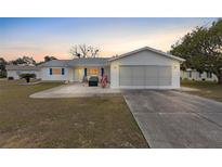 Single story home with a paved driveway and a well-maintained lawn at 10662 Se 174Th Loop, Summerfield, FL 34491