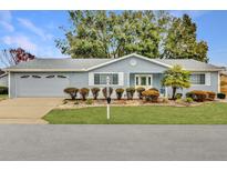 Ranch-style home with gray siding, mature landscaping, and a two-car garage at 11631 Sw 82Nd Ter, Ocala, FL 34481