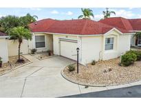 Charming single-story home featuring a red roof, well-maintained landscaping, and an attached garage at 1330 Lajolla Cir, The Villages, FL 32159