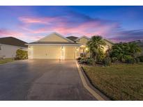 Beautiful two-story house with a three-car garage and manicured lawn at 2131 Baldwin Run, The Villages, FL 32162