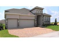 Two-story house with two-car garage and brick accents at 2137 Sunshine Peak Dr, Minneola, FL 34715