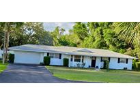Charming single-story home with a manicured lawn, black shutters, and a two-car attached garage at 2937 Eagles Nest Rd, Fruitland Park, FL 34731