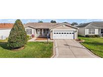 Single-story house with a two-car garage and landscaped front yard at 3525 Idlewood Loop, The Villages, FL 32162