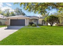 Single-story home with a two-car garage and lush lawn at 3793 Beacon Ridge Way, Clermont, FL 34711