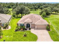 Inviting one-story home with a meticulously manicured front yard, mature trees, and a long driveway at 3809 Arlington Ridge Blvd, Leesburg, FL 34748