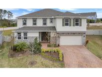 Two-story home with stone accents and a brick driveway at 410 Cheeota Ct, Minneola, FL 34715