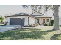 One-story home with attached garage and manicured lawn at 5622 Sir Churchill Dr, Leesburg, FL 34748