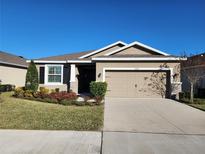 One-story home with two-car garage, landscaping, and a neutral color palette at 8065 Penrose Pl, Wildwood, FL 34785