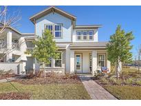 Two-story light blue house with gray accents and a landscaped front yard at 10093 Pearson Ave, Orlando, FL 32827