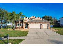 Attractive two-story house with three-car garage and palm trees at 12532 Hammock Pointe Cir, Clermont, FL 34711