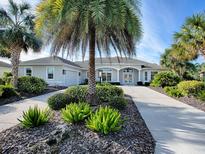 Beautiful home exterior with palm trees and landscaped yard at 1369 Harley Cir, The Villages, FL 32162