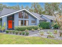 Charming home featuring a brightly colored front door, lush landscaping, and a modern design at 1701 Cedar Stone Ct, Lake Mary, FL 32746