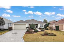 Single-story home with a landscaped front yard and attached garage at 2080 Nordic Ln, The Villages, FL 32163