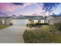 Charming one-story house with a landscaped lawn and attached garage at 2304 Jonebury Run, The Villages, FL 32162