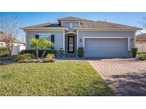 One-story home with gray siding, brick accents, and a two-car garage at 24506 Woodhill Ct, Sorrento, FL 32776