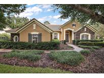 Beautiful two-story home with stone accents and lush landscaping at 25833 Feather Ridge Ln, Sorrento, FL 32776