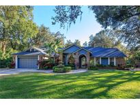 Beautiful blue house with mature landscaping and a large lawn at 2614 W Ponkan Rd, Apopka, FL 32712