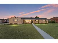 Brick ranch house with landscaped lawn and walkway at 3437 Starfish Ave, Fruitland Park, FL 34731