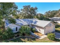 Brick home with mature landscaping and a two-car garage at 36703 Sandy Ln, Grand Island, FL 32735