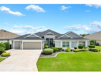 Beautiful two-story house with a three-car garage and landscaped lawn at 3795 View Path, The Villages, FL 32163