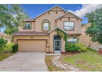 Two-story house with a landscaped lawn, stone pathway, and attached garage at 5036 Gandross Ln, Mount Dora, FL 32757