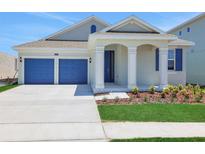 Charming home features a two-car garage, covered entryway, and manicured lawn, creating curb appeal at 5095 Firebush Dr, Apopka, FL 32712