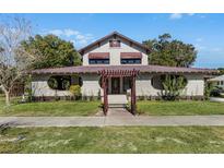 Charming two-story home with unique architectural features and manicured landscaping at 211 Cassady St, Umatilla, FL 32784