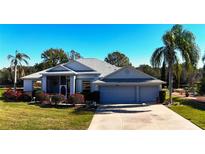 Charming single-story home featuring a three-car garage, screened porch, and well-manicured landscaping at 24308 Belle Mede Dr, Leesburg, FL 34748