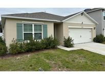 Single-story house with a two-car garage and landscaping at 29320 Armoyan Blvd, Leesburg, FL 34748