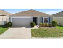 One-story house with gray siding, two-car garage, and landscaped yard at 417 Pinecrest Loop, Davenport, FL 33837