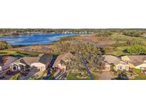 Aerial view of a charming single Gathering home with lush landscaping, a lake, and golf course views at 4822 Sawgrass Lake Cir, Leesburg, FL 34748