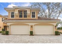 Tan two-story home with two-car garage and landscaped front at 14 Camino Real Blvd # 14, Howey In The Hills, FL 34737